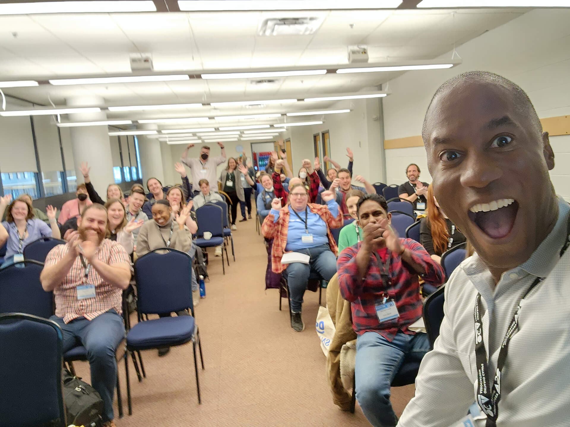 Chris Hudson doing an energetic group selfie.